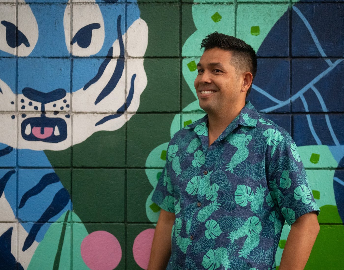 Man in the Monstera Pineapple aloha shirt in front of a mural